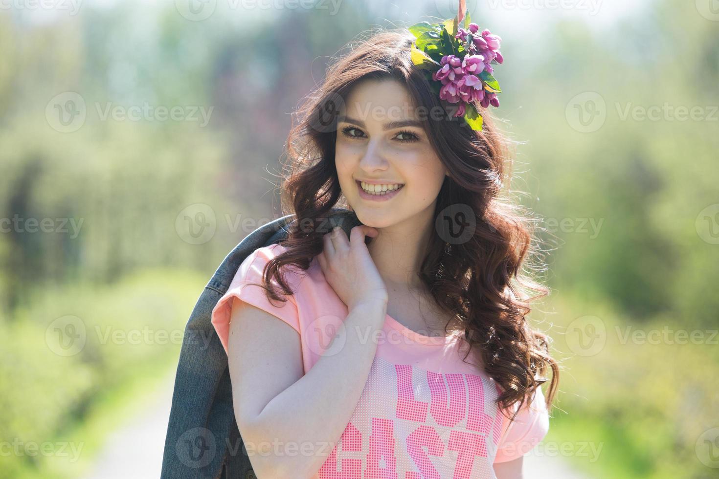 mooi wit europees meisje met schone huid in het park met bloeiende bomen foto