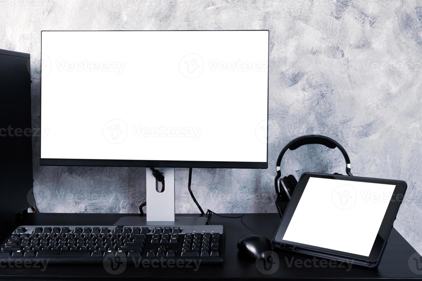 zwarte computer en tablet op het bureau. foto