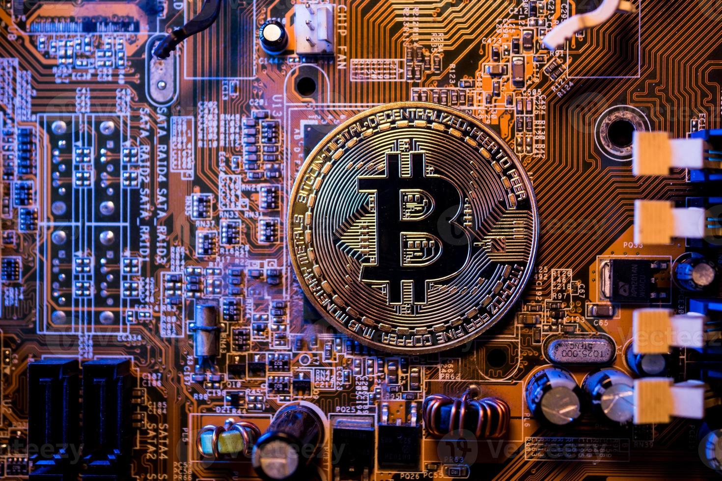 gouden munten met bitcoin-symbool op een moederbordcomputer. foto