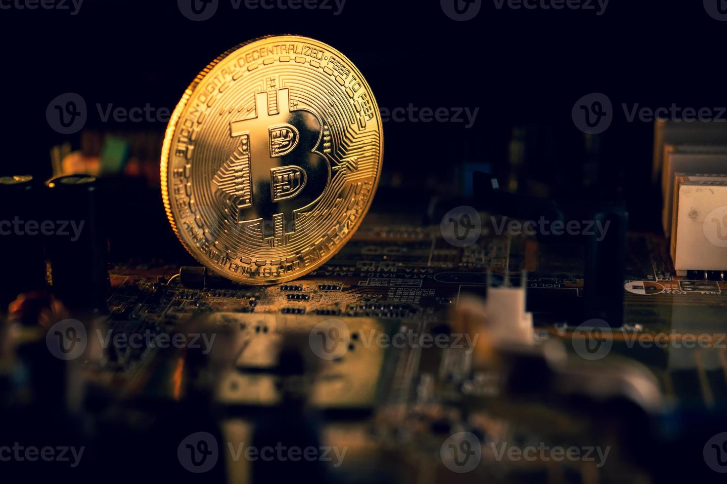een gouden munt met bitcoin-symbool op een moederbord. foto