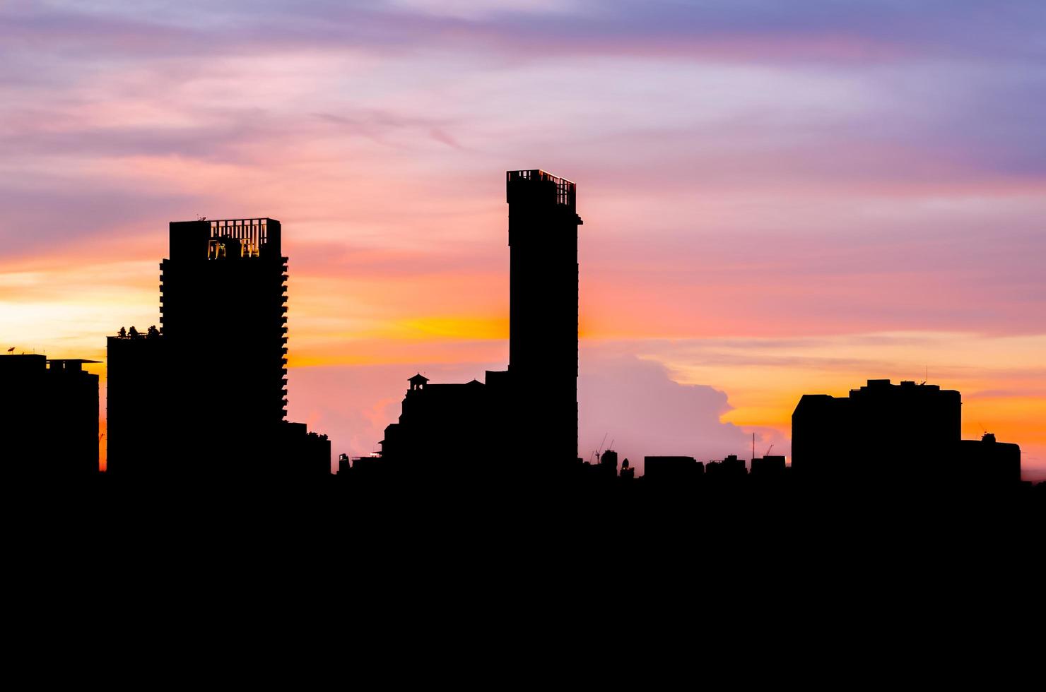 kleurrijke schemerhemel in de avond met silhouet van veel gebouwen in de stad. foto