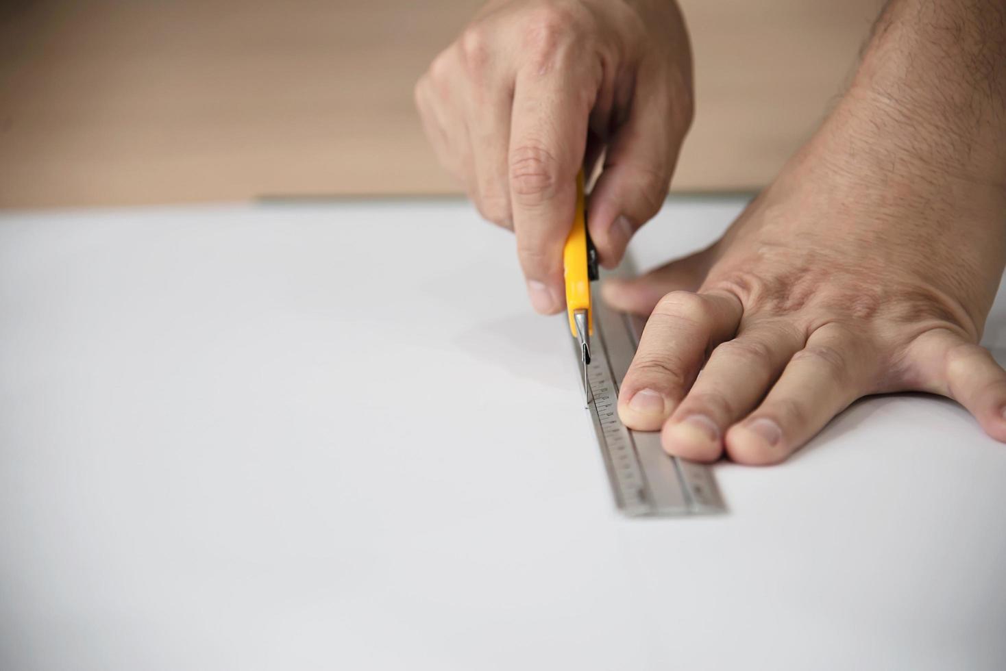 man met behulp van maatregel handgereedschap doet behang snijden werk in huis bouwplaats, mensen met handgereedschap object concept foto