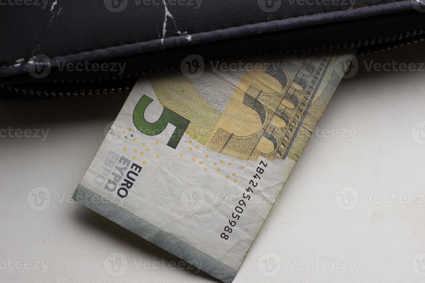 contant geld van vijf euro steekt uit zwarte portemonnee, horizontale foto. economisch crisisconcept, geld, inflatie. modern bankbiljet van landen van de europese unie foto