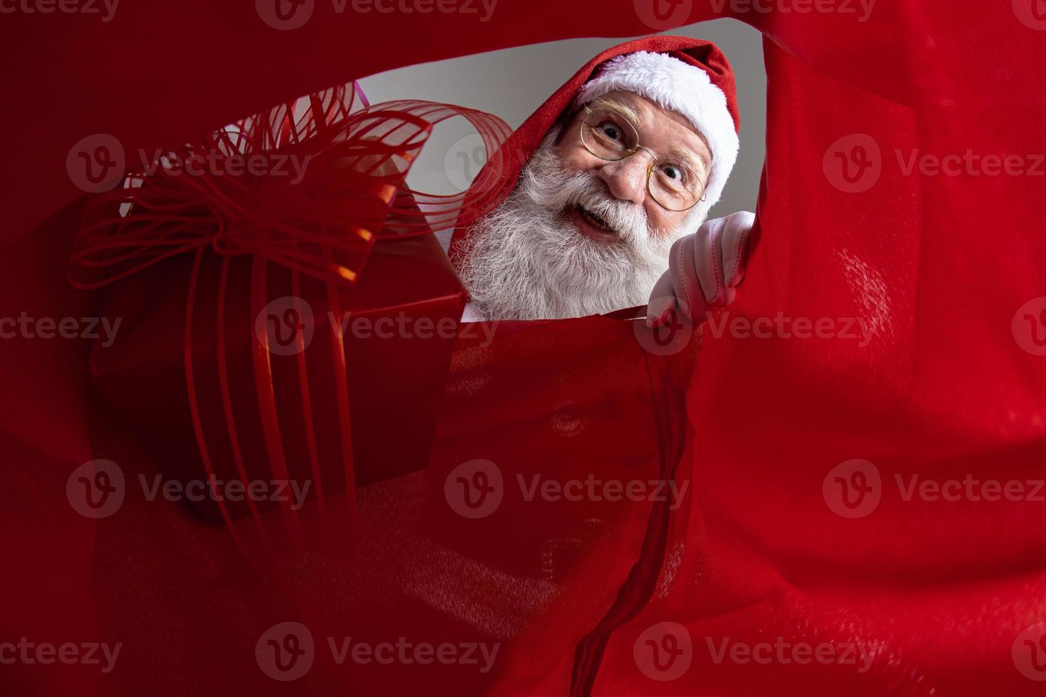 afbeelding van binnenuit de zak, de kerstman stopt geschenken in de zak. foto