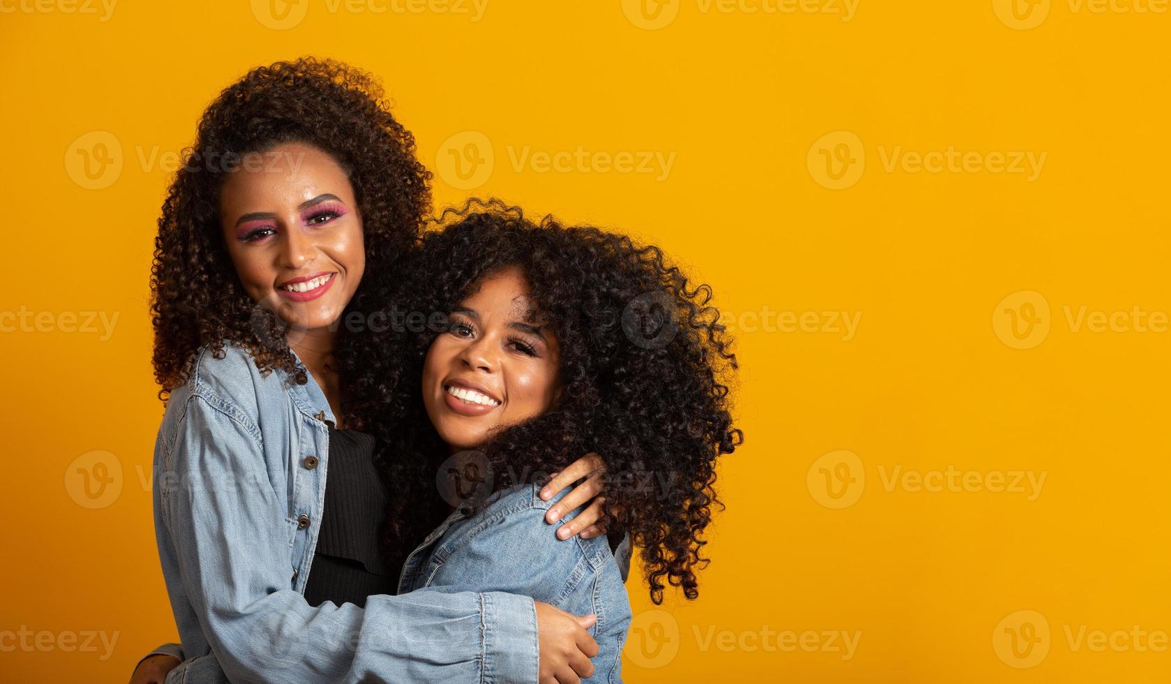 twee mooie afro-vrienden omhelsde, concept van beste vrienden en zussen. foto