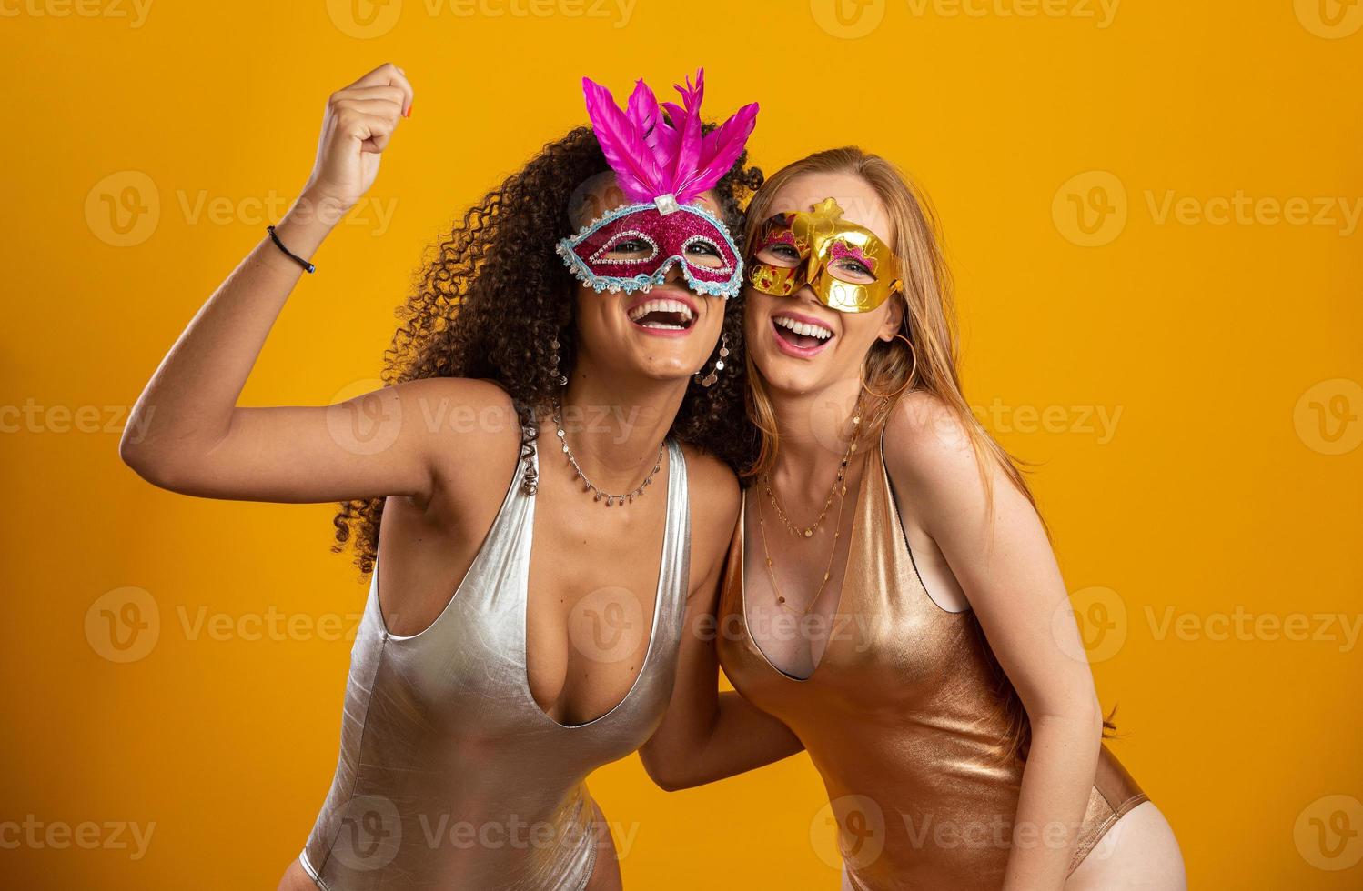 mooie vrouwen gekleed voor carnaval nacht. lachende vrouwen klaar om te genieten van het carnaval met een kleurrijk masker. foto