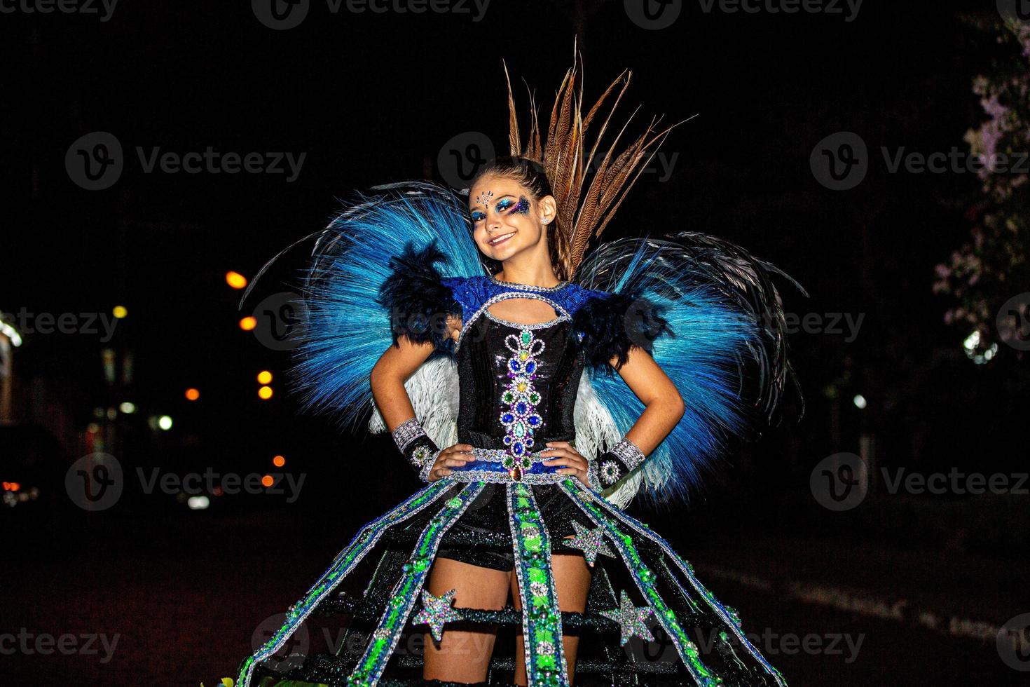 Braziliaanse tiener die sambakostuum draagt. mooie braziliaanse jongen vrouw dragen kleurrijke kostuum en glimlachen tijdens carnaval straatparade in brazilië. foto