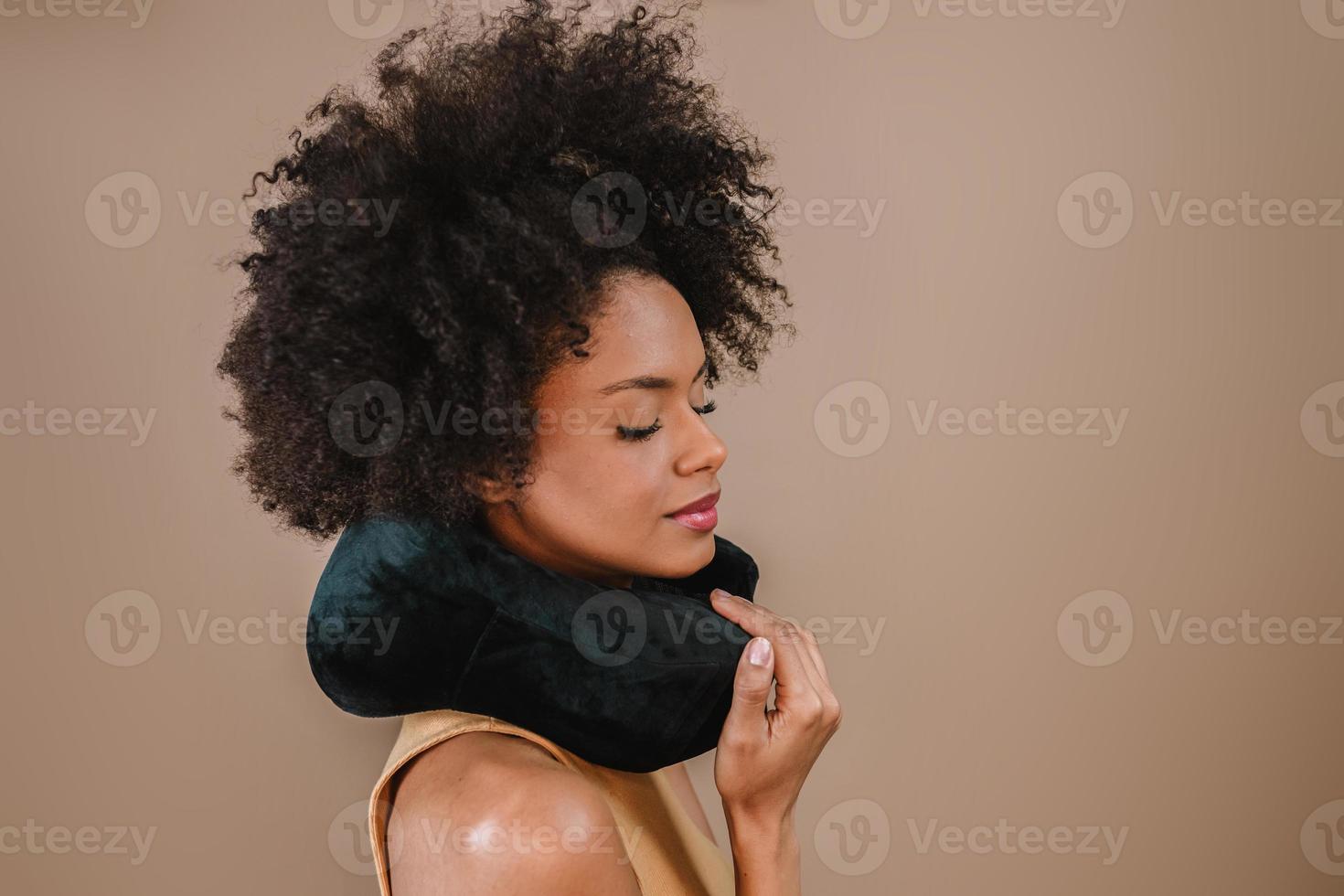 jonge knappe latijnse vrouw kussen nek reizen naar het buitenland vlucht comfort geïsoleerd over pastel bruine kleur achtergrond foto
