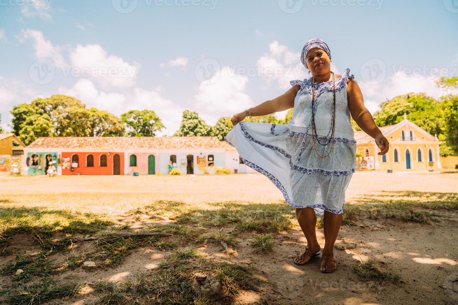 gelukkige braziliaanse vrouw gekleed in het traditionele bahiaanse kostuum van de umbanda-religie, in het historische centrum van porto seguro foto