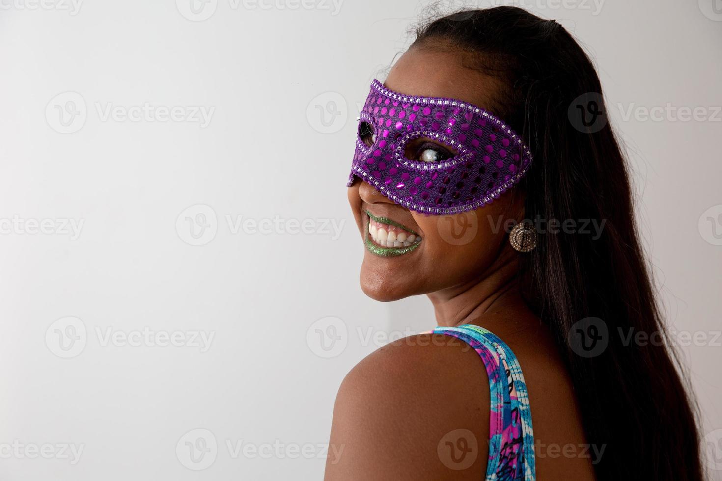 gelukkige jonge vrouw met masker en confetti op carnavalsfeest. braziliaans carnaval foto