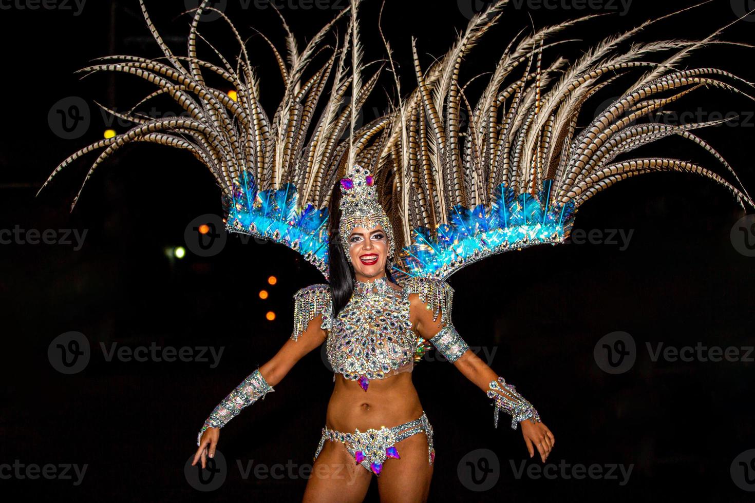 brazilian die sambakostuum draagt. mooie braziliaanse vrouw die kleurrijk kostuum draagt en glimlacht tijdens carnaval straatparade in brazilië. foto