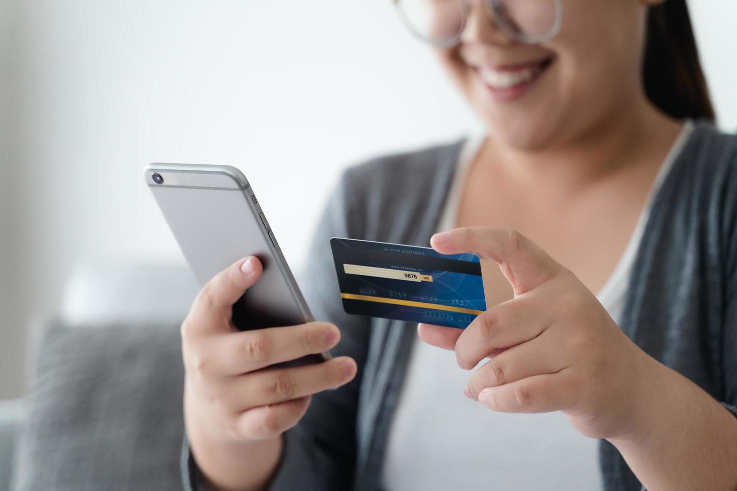 vrouw met creditcard en smartphone gebruiken voor online winkelen, internetbankieren, e-commerce, geld uitgeven. foto