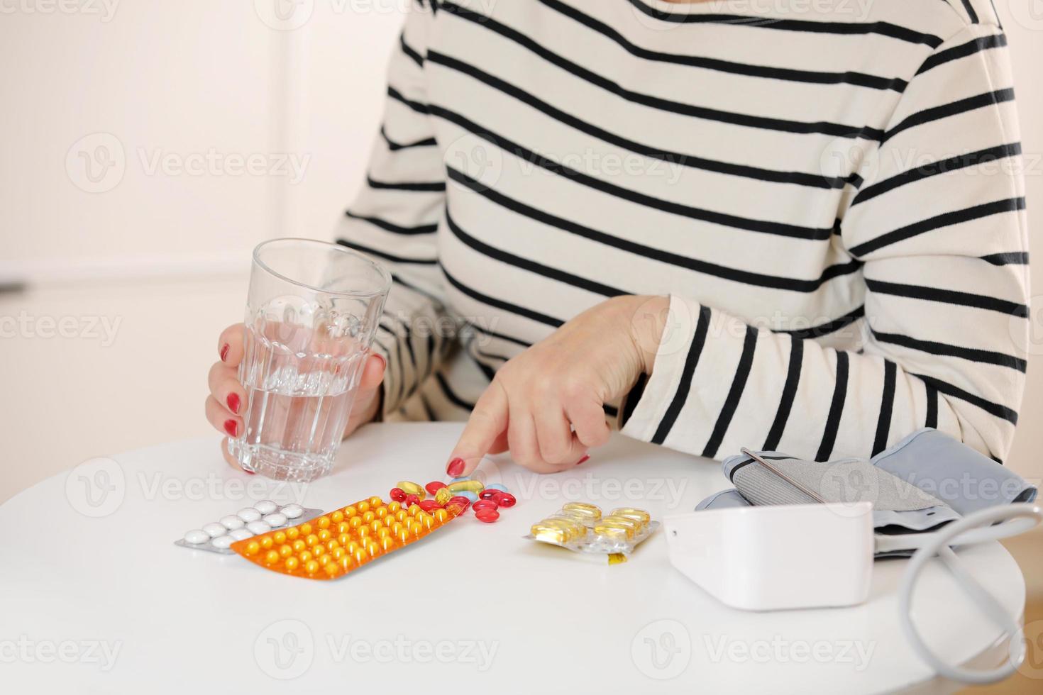 oudere vrouw houdt glas water vast en antibioticum aspirine pil voelt zich ongezond thuis, zieke volwassen vrouw neemt dagelijkse dosis supplemolder vrouw houdt glas water vast. ouderenzorgconcept. foto