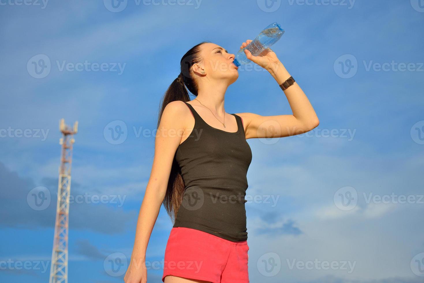 vrouw drinkwater uit de fles foto