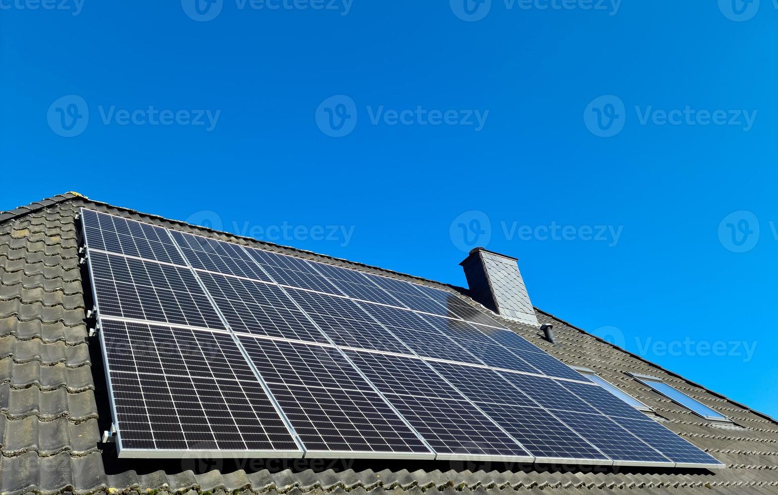 zonnepanelen die schone energie produceren op een dak van een woonhuis foto