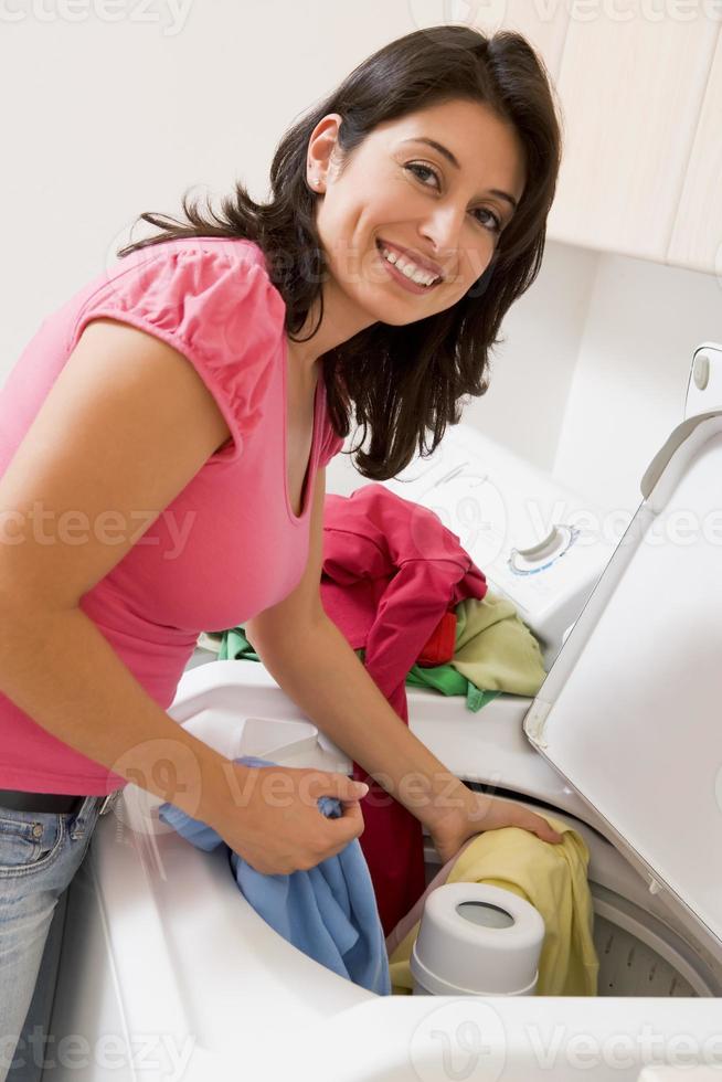 glimlachende vrouw die kleurrijke kleren wast foto