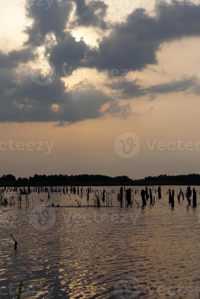 meer tijdens zonsondergang met geeloranje lucht foto