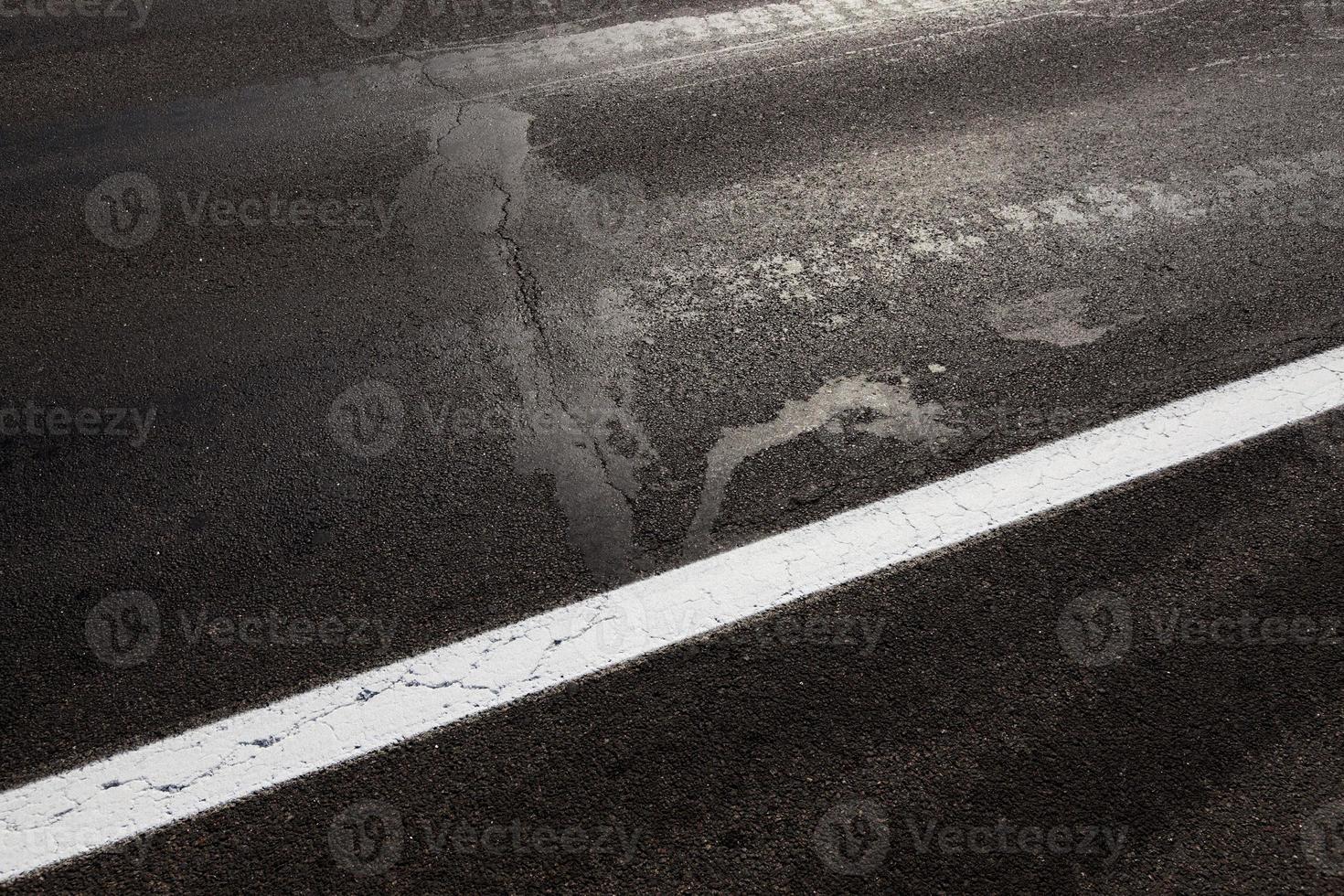 verharde weg, een close-up van een deel van de rijbaan van een asfaltweg foto