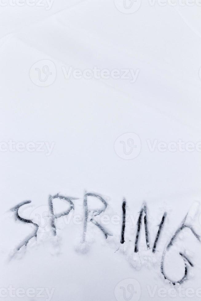 de woorden lente getekend op de sneeuw foto