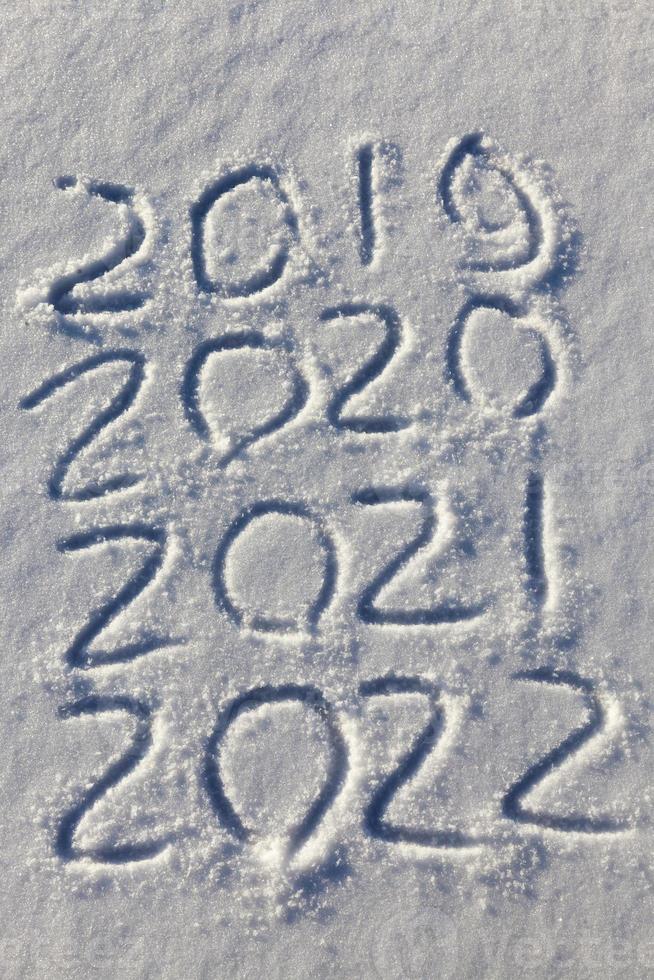 de inscriptie over het nieuwe jaar 2022 op de sneeuw in de winter foto