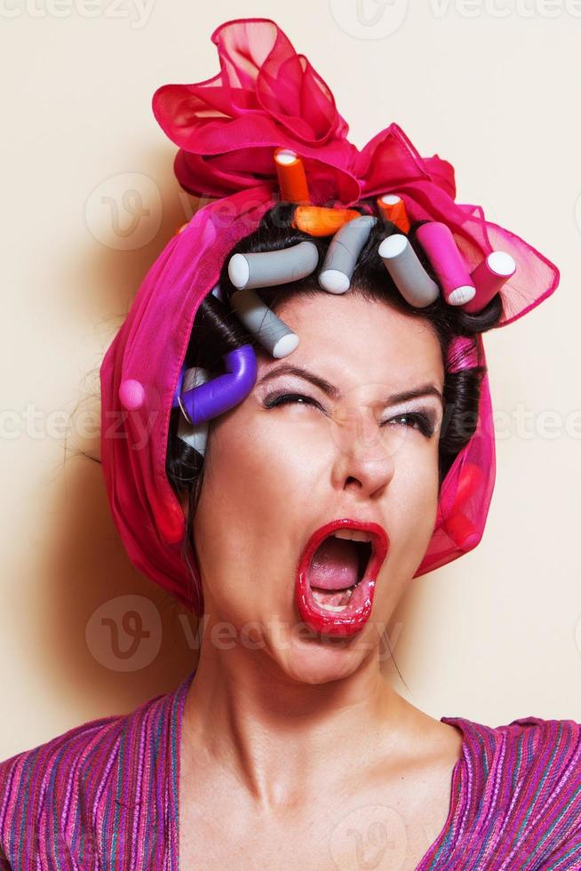 close-up van een jonge vrouw met haar krulspelden een grimas maken foto