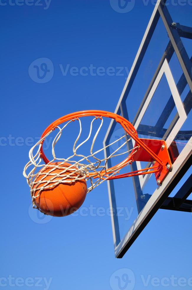 basketbal schot vallen door de netto, blauwe lucht foto