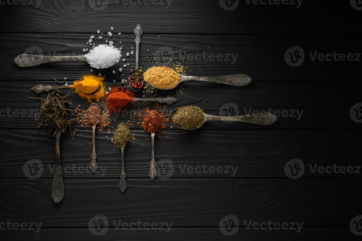 kleurrijke verschillende kruiden en specerijen voor het koken op donkere houten rustieke achtergrond foto