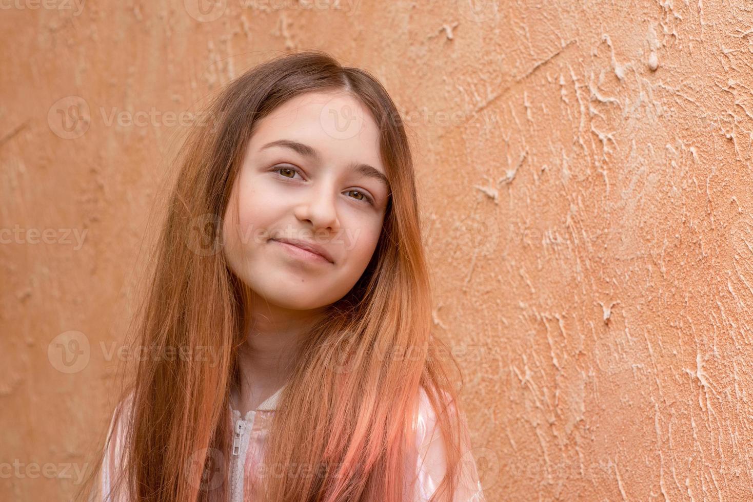 meisje 11 jaar oud op een achtergrond van beige muur. tiener meisje portret. foto