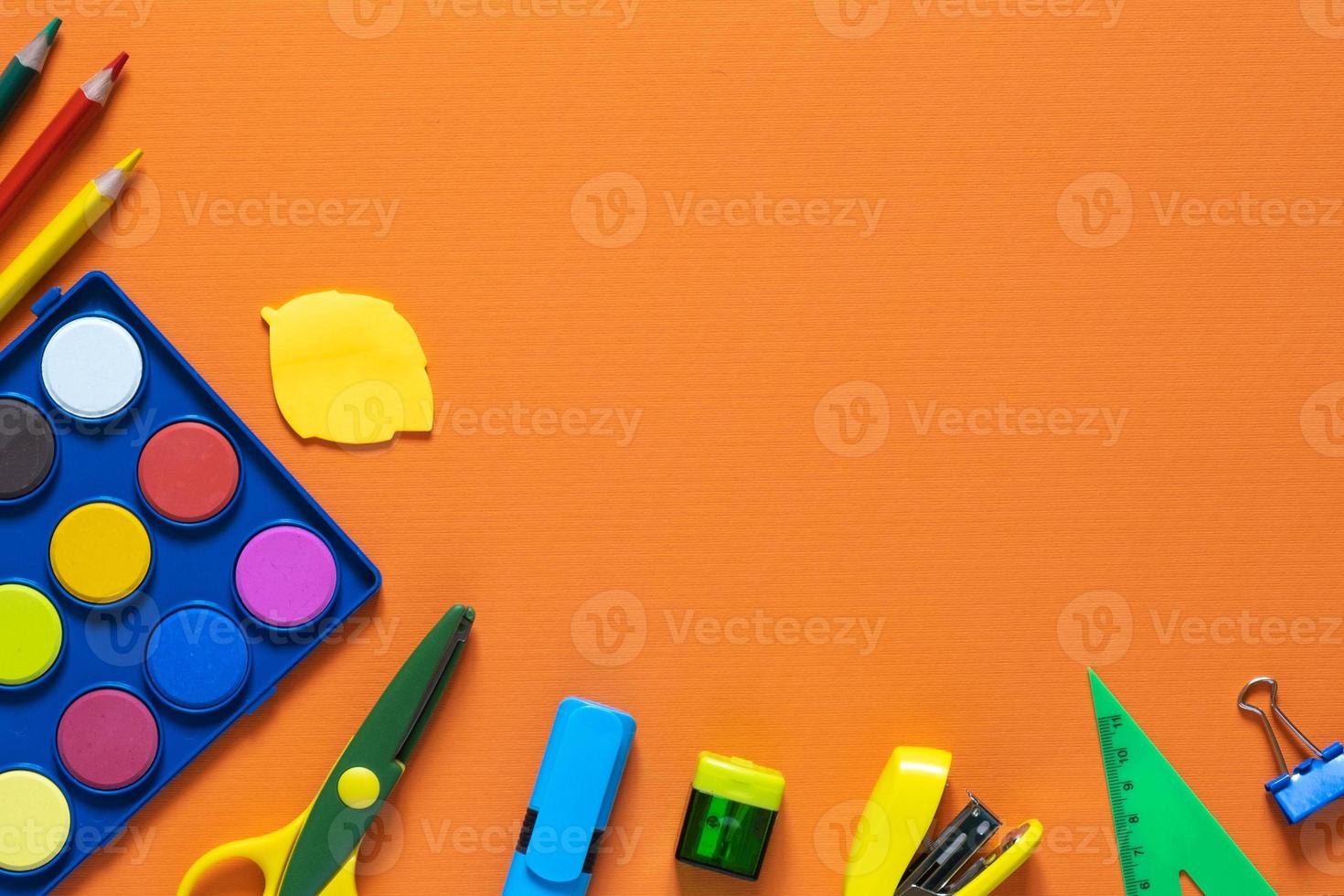 terug naar schoolconcept. school- en kantoorbenodigdheden op de kantoortafel. oranje background.flat lay.herfst foto