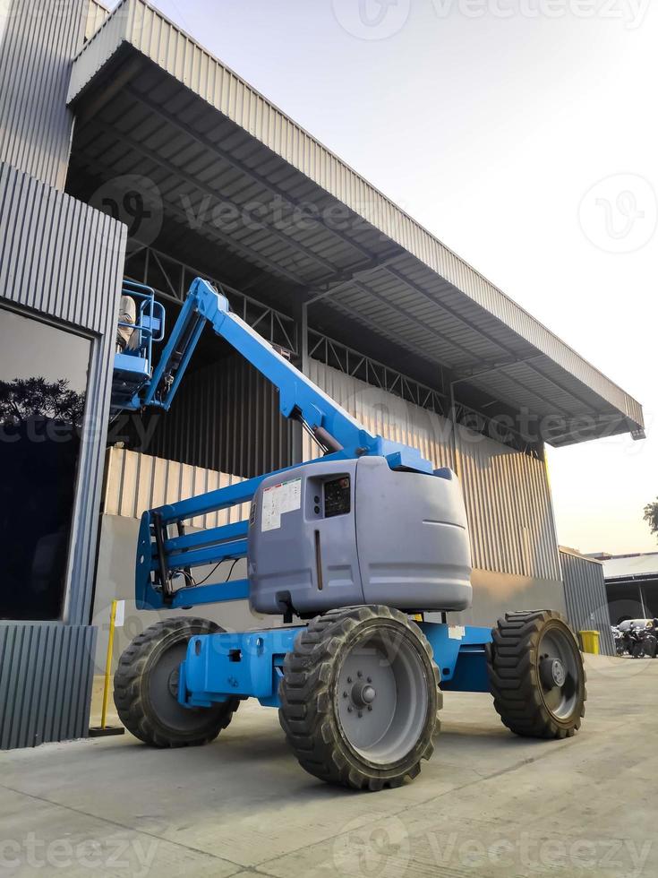 manlift kraan met platform hijsen naar het dak van een gebouw foto