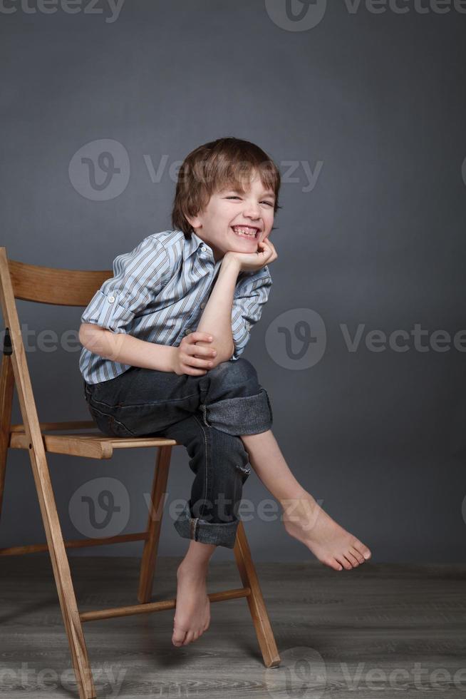 portret van blij, vreugde jongen op een grijze achtergrond foto