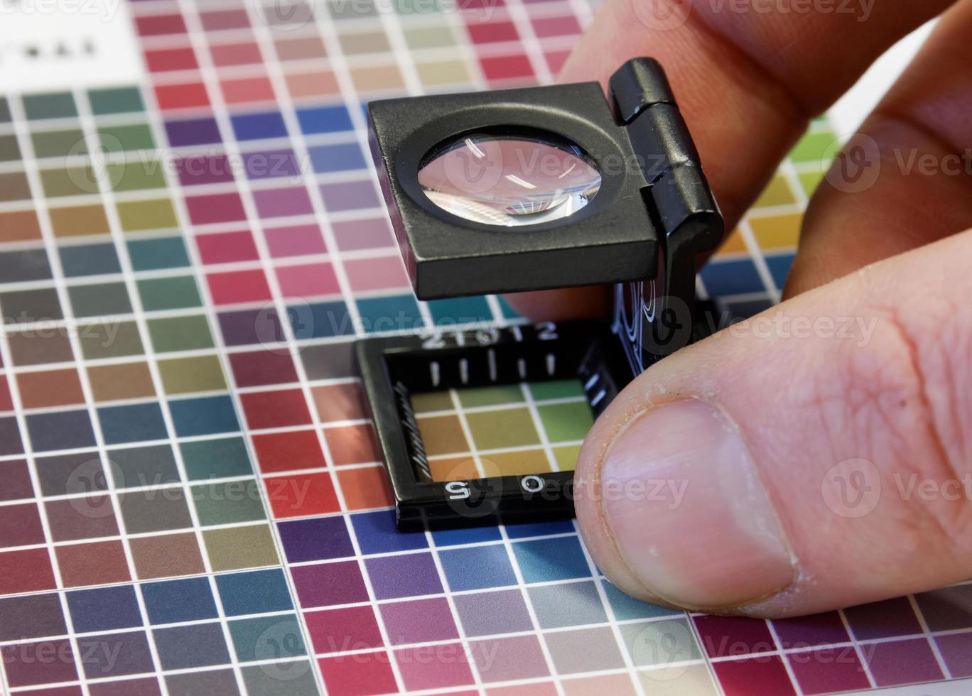 close-up van een loep op een kleurrijke testafdruk foto