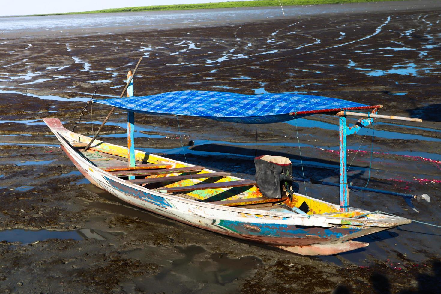 kleine boot op het strand met troebel water foto
