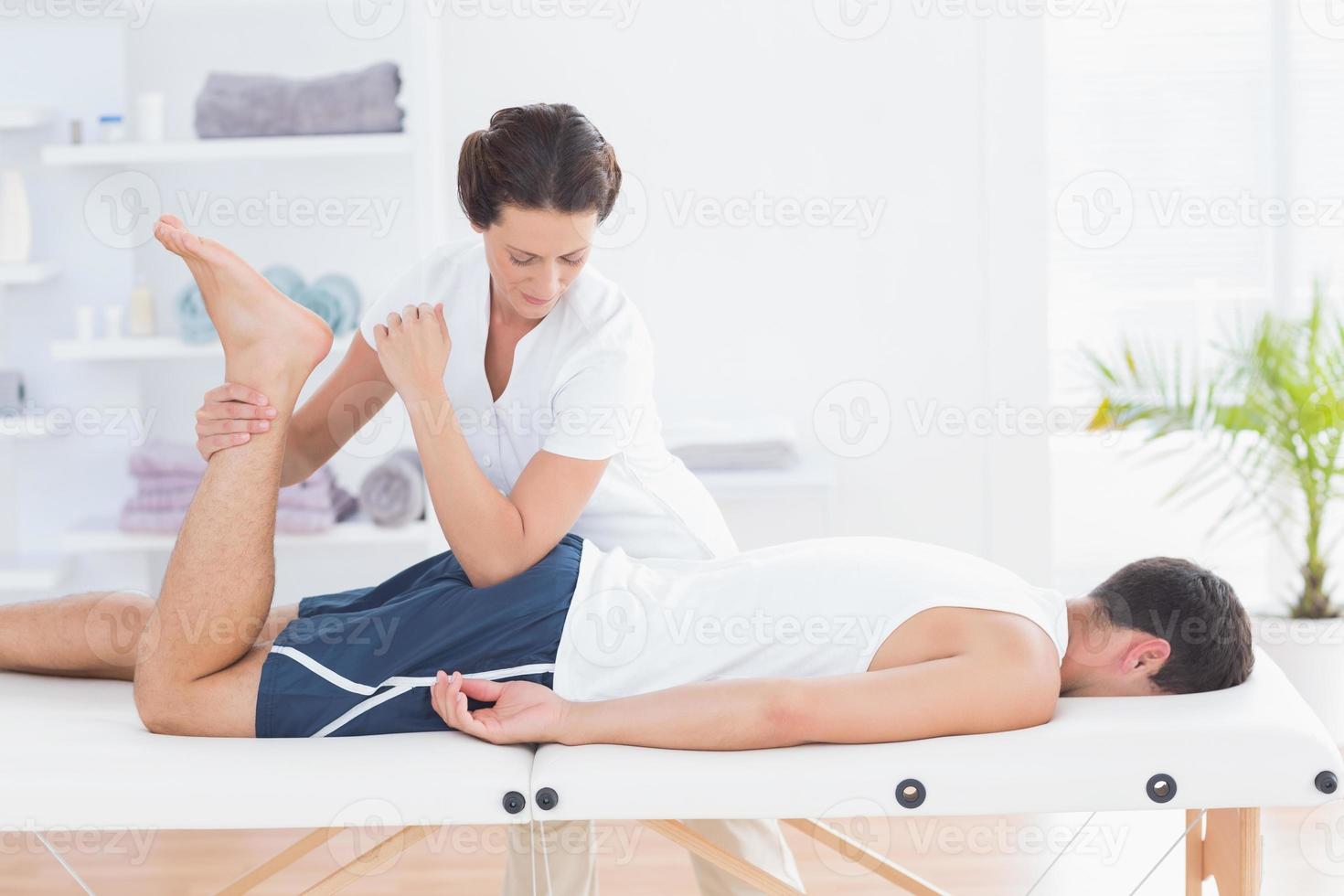 fysiotherapeut die beenmassage doet foto