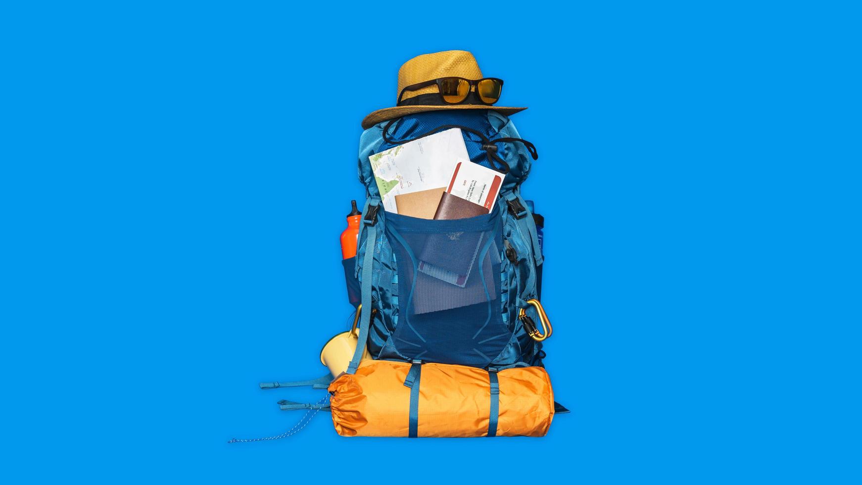 toeristische planning vakantie met behulp van wereldkaart met andere reisaccessoires in de buurt. concept bagage met accessoire voor reizigers vakantie op blauwe kleur achtergrond. reis rugzak foto