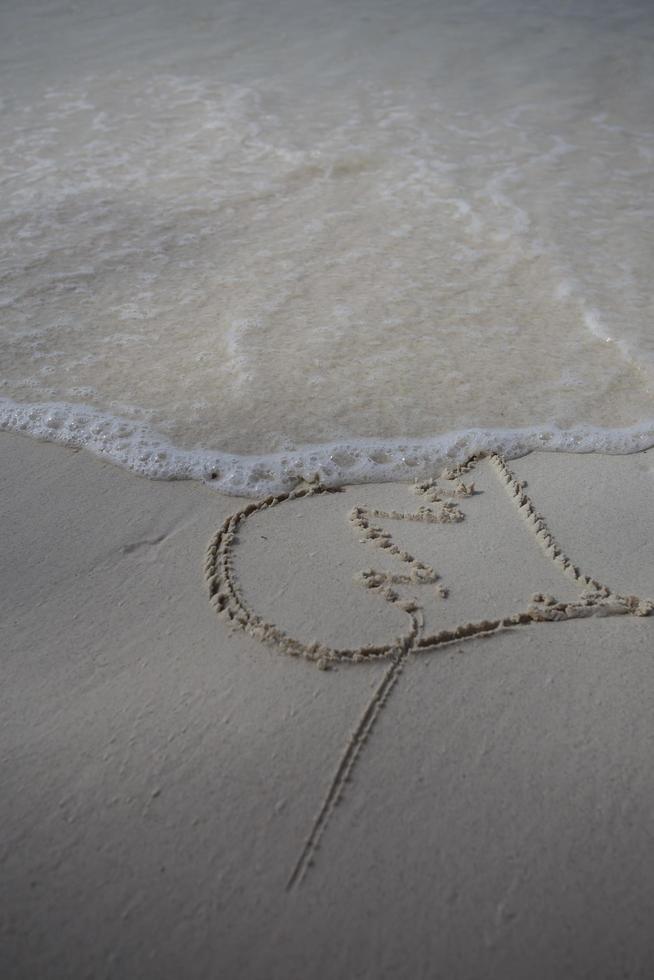 harten getekend op het zand van een strand foto