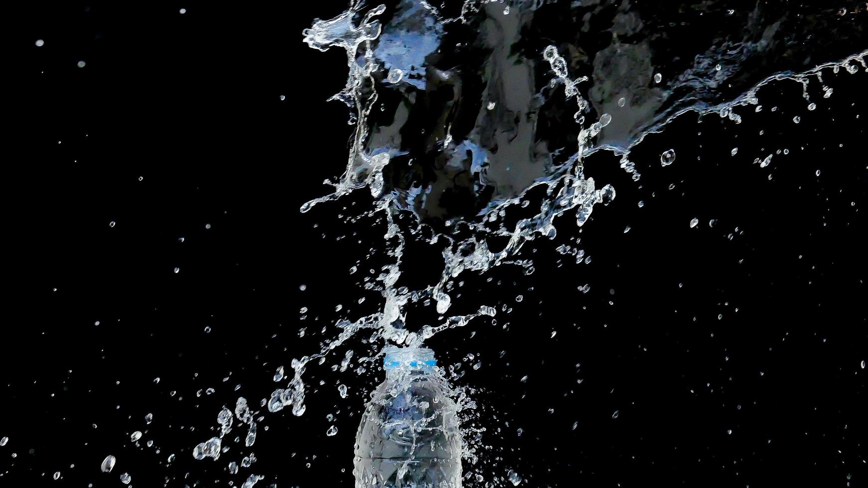 abstracte waterstraal stort neer op een zwarte achtergrond foto
