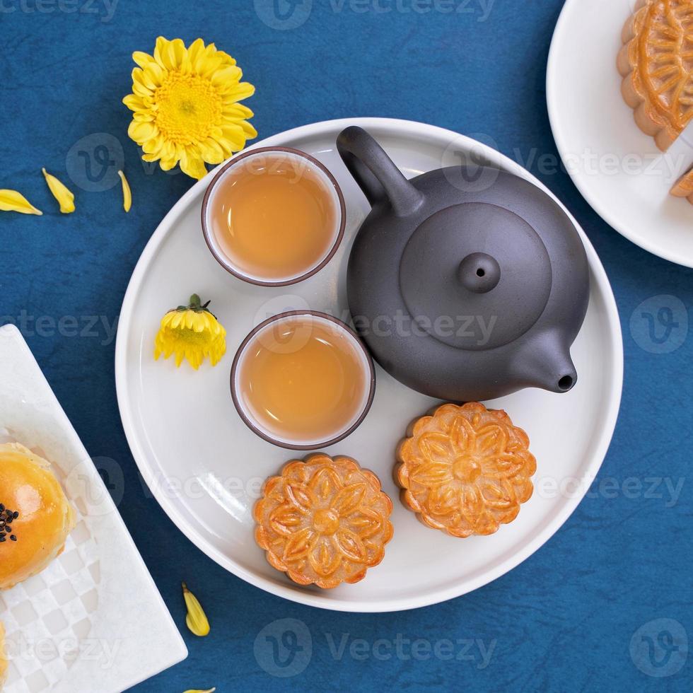 maancake voor mid-herfstfestival, heerlijke mooie verse mooncake op een bord over blauwe achtergrondtafel, bovenaanzicht, plat lay-outontwerpconcept. foto