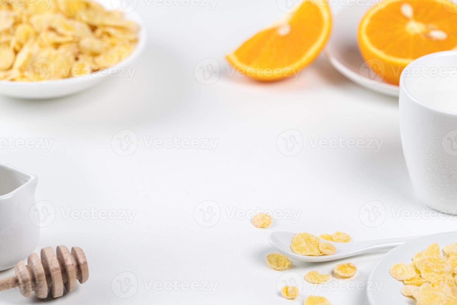 cornflakes kom snoepjes met melk en sinaasappel op witte achtergrond, close-up, vers en gezond ontbijt ontwerpconcept. foto