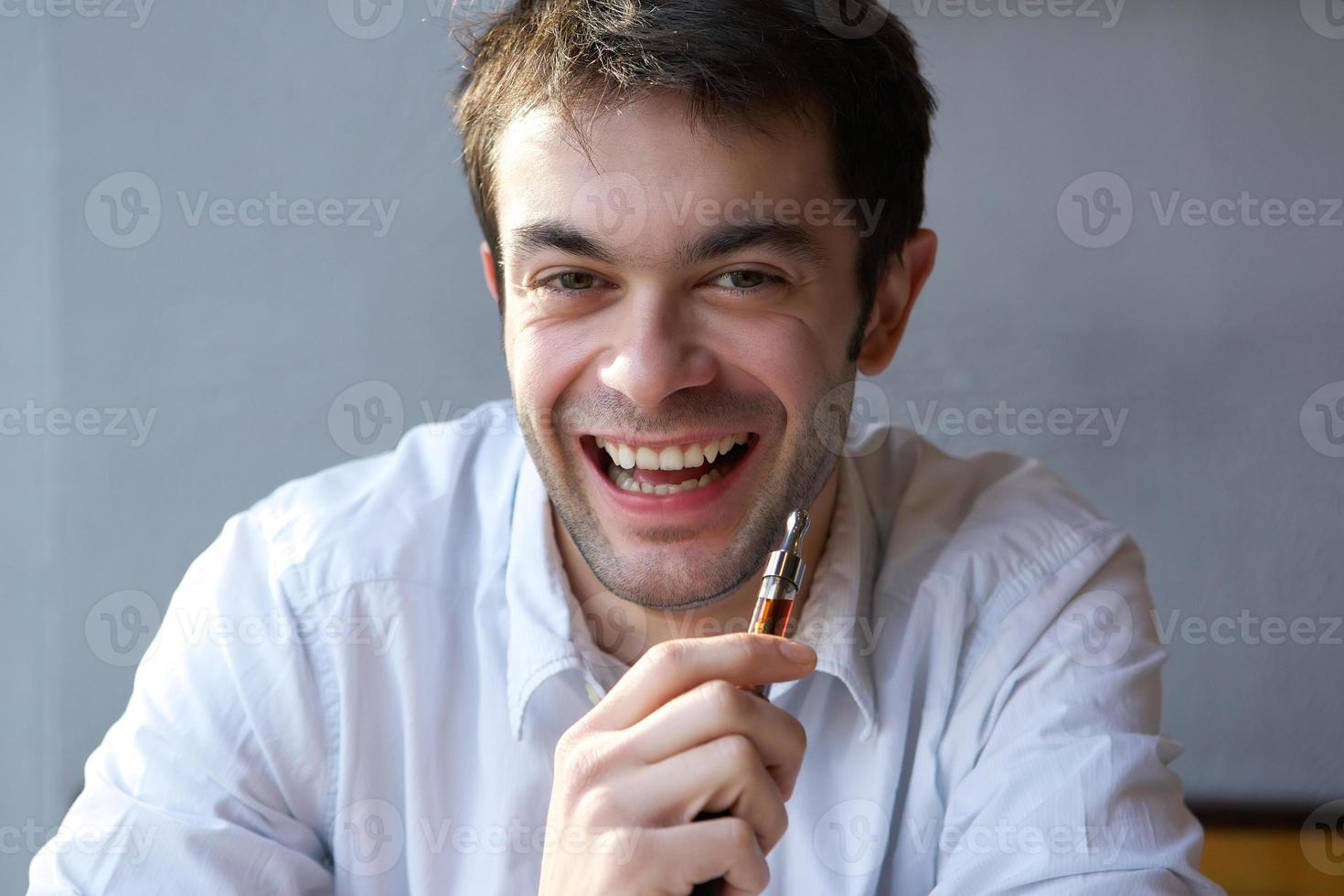 gelukkig jonge man met elektrische sigaret foto