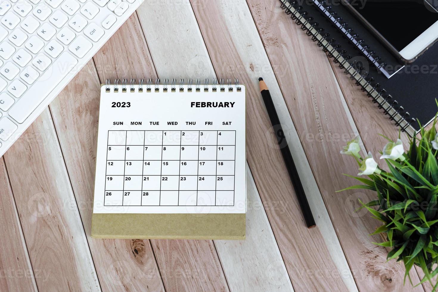 witte februari 2023 kalender tegen houten bureau foto