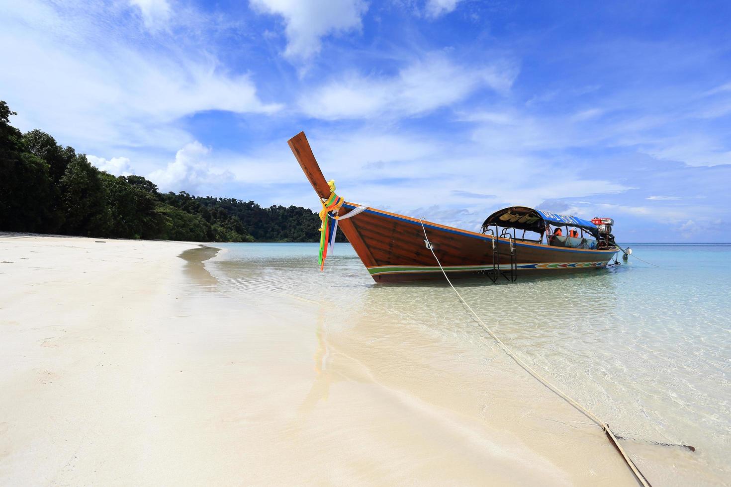 lange staartboot op wit zandstrand op tropisch eiland foto