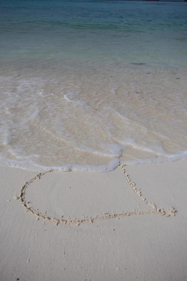 harten getekend op het zand van een strand foto