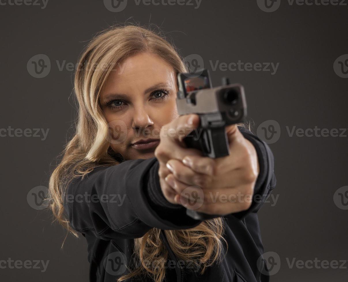focus op vrouw shooter gericht pistool. foto