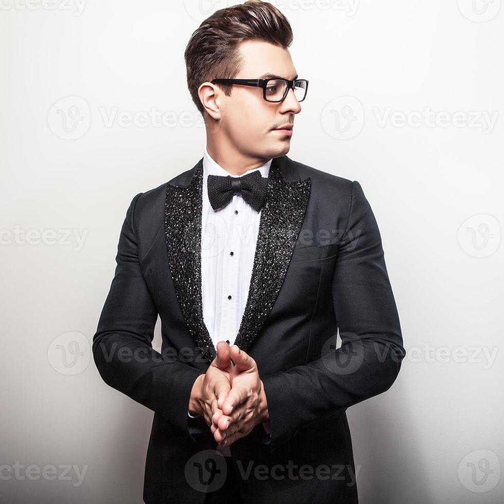 elegante jonge knappe man in zwarte luxe kostuum. foto