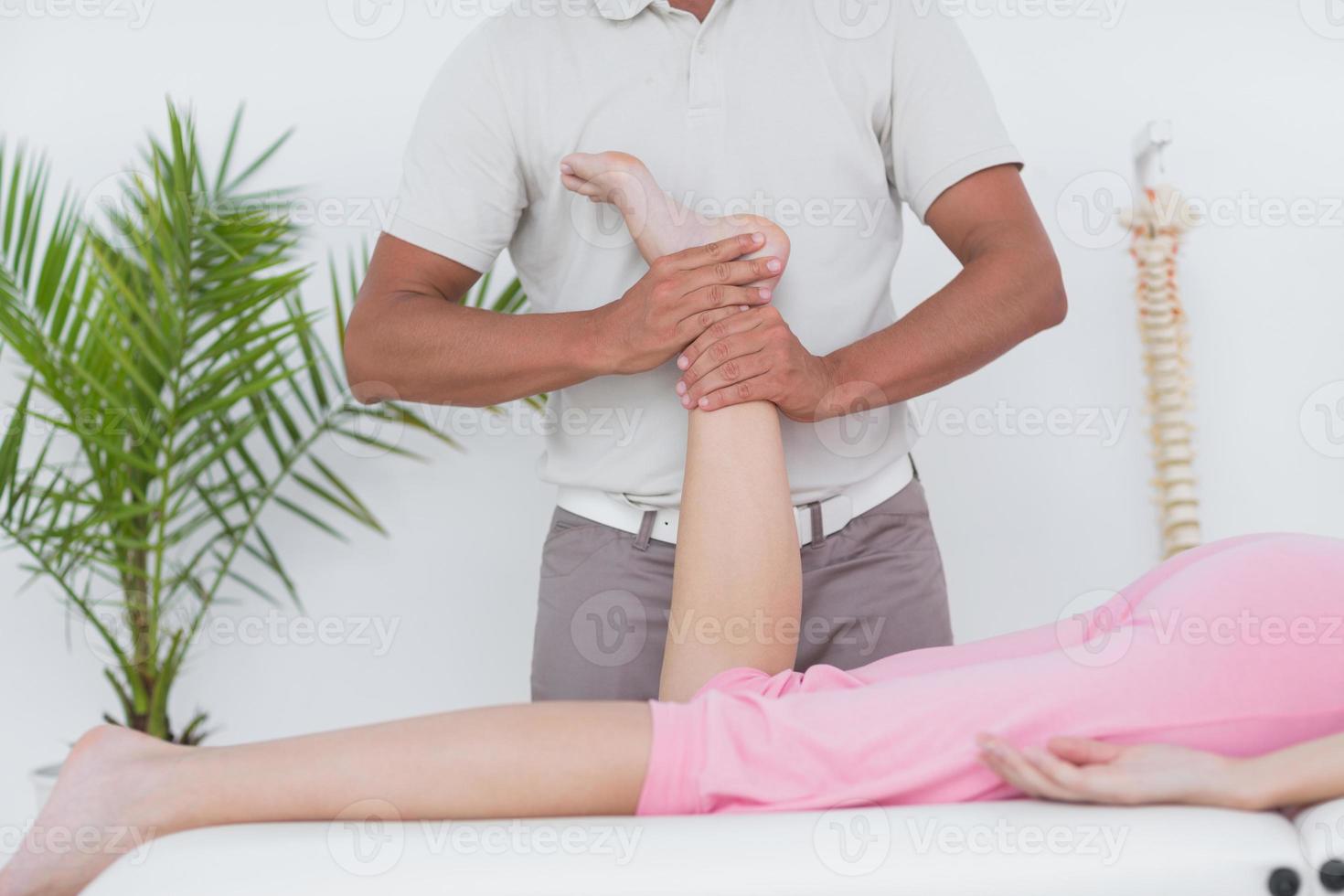 fysiotherapeut die beenmassage doet aan zijn patiënt foto