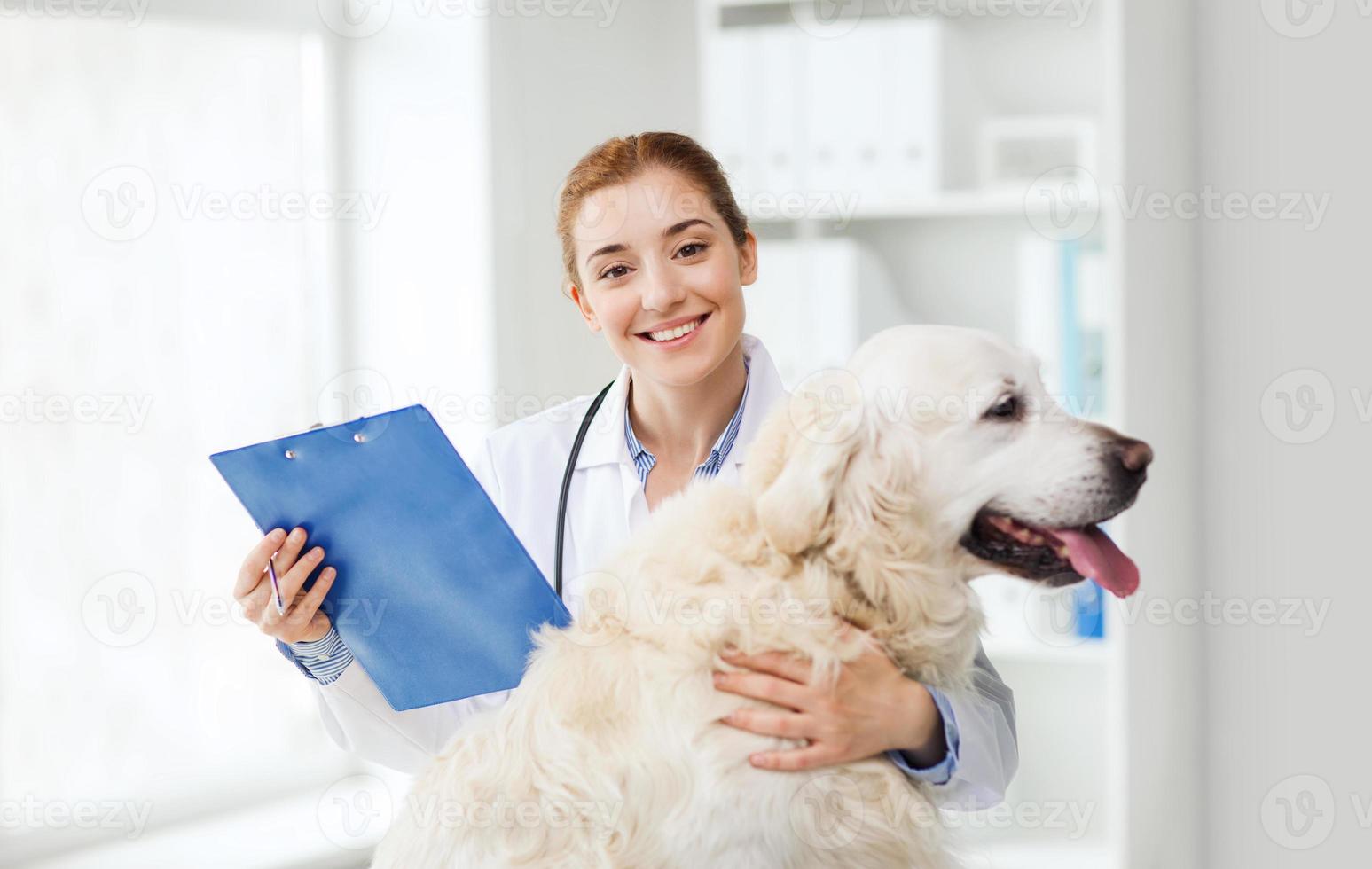 gelukkige arts met retrieverhond bij dierenartskliniek foto