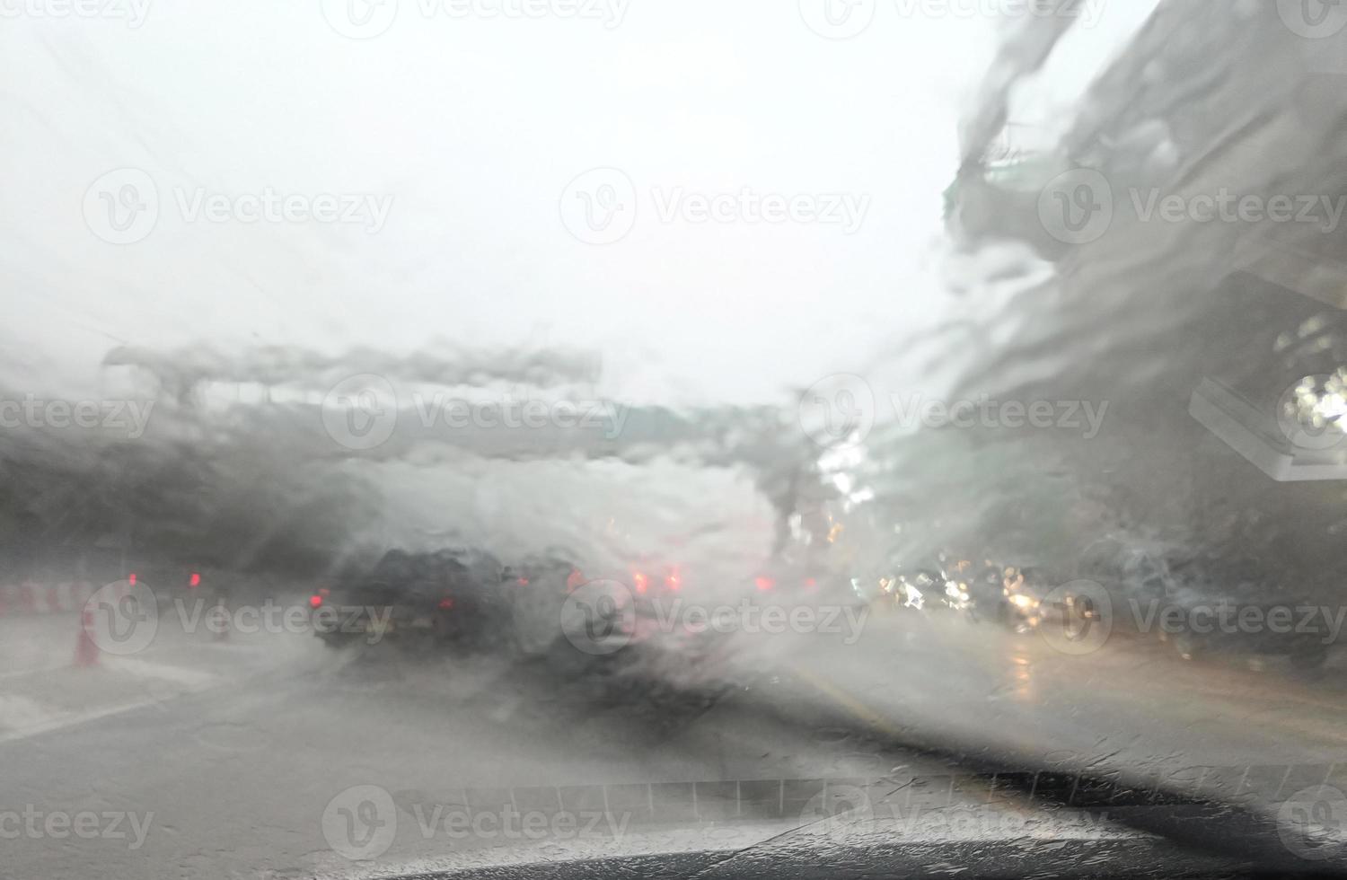 wegzicht door autoraam met zware regen en stormhits rijden in de regen, verkeerszicht vanaf de voorruit van de auto in de regen, rijden in de regen foto
