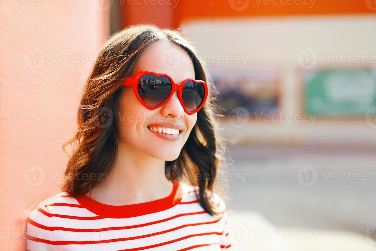 portret van vrij lachende vrouw in rode zonnebril buitenshuis foto