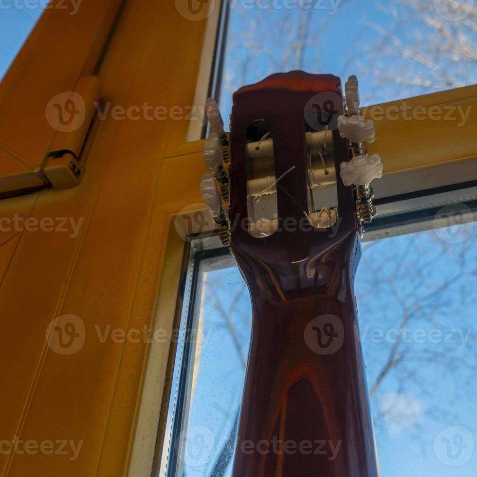 de gitaarhals leunt tegen het raam foto